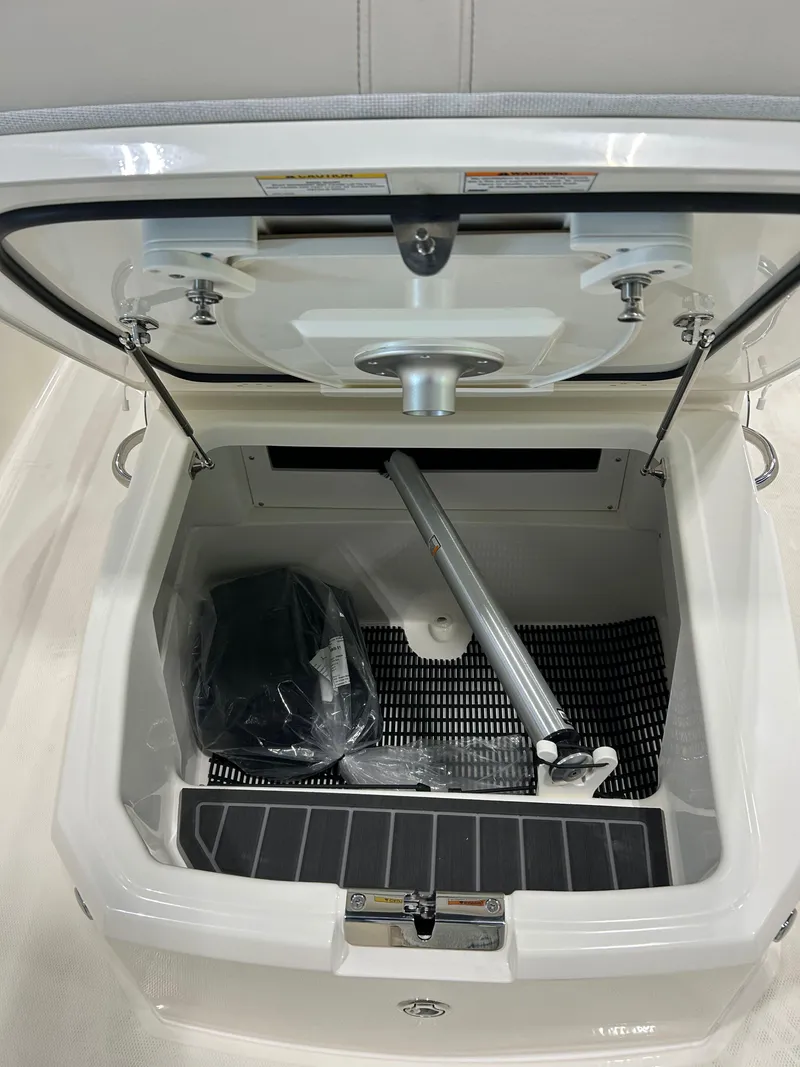 Slide: The Image of Open storage compartment of 2025 Boston Whaler 220 Dauntless boat, showing interior details. - 13