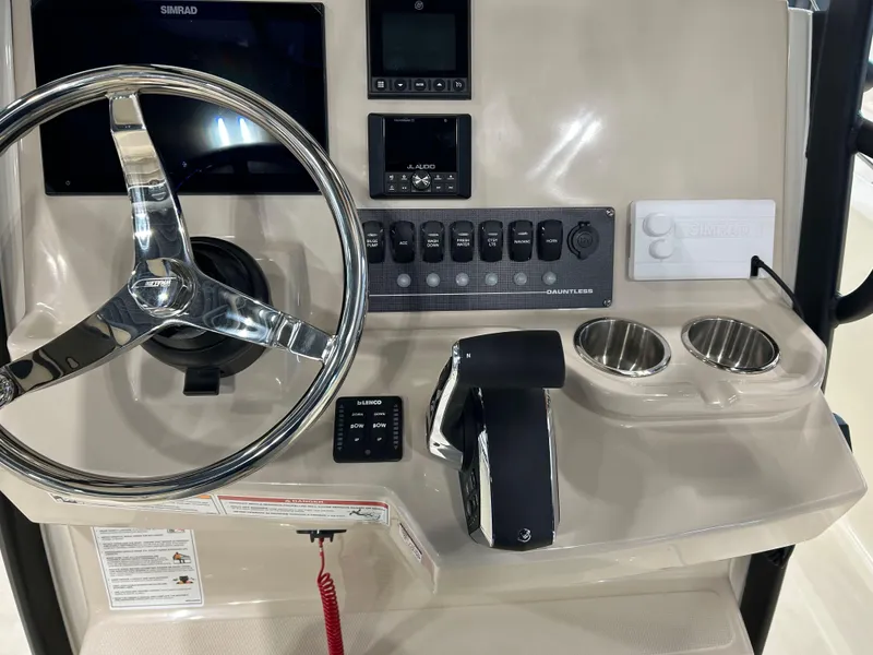 Slide: The Image of Control panel of 2025 Boston Whaler 220 Dauntless boat with steering wheel and switches. - 15