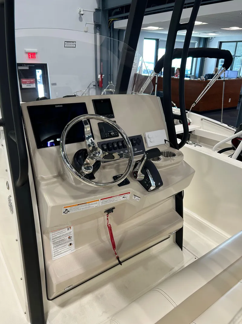Slide: The Image of 2025 Boston Whaler 220 Dauntless boat console with steering wheel and controls. - 3