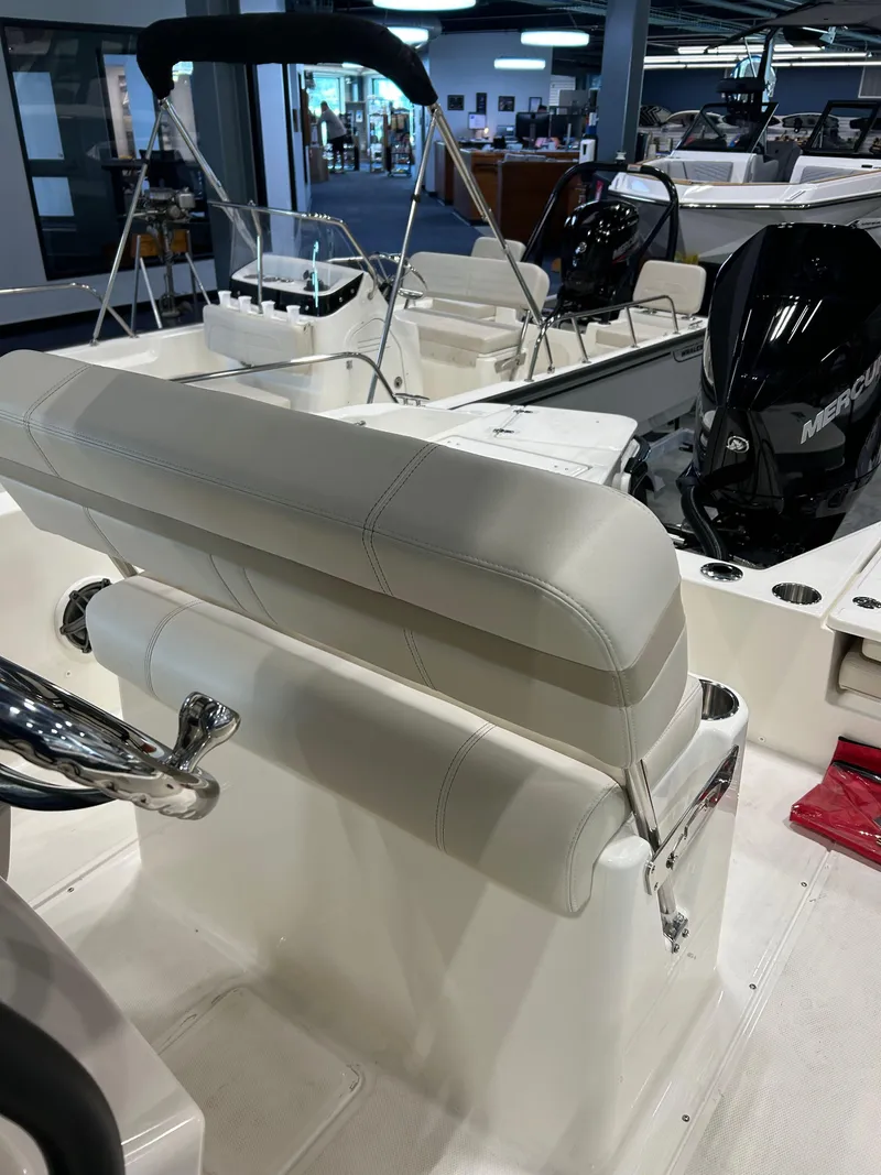 Slide: The Image of 2025 Boston Whaler 220 Dauntless boat interior with seating and Mercury engine. - 5