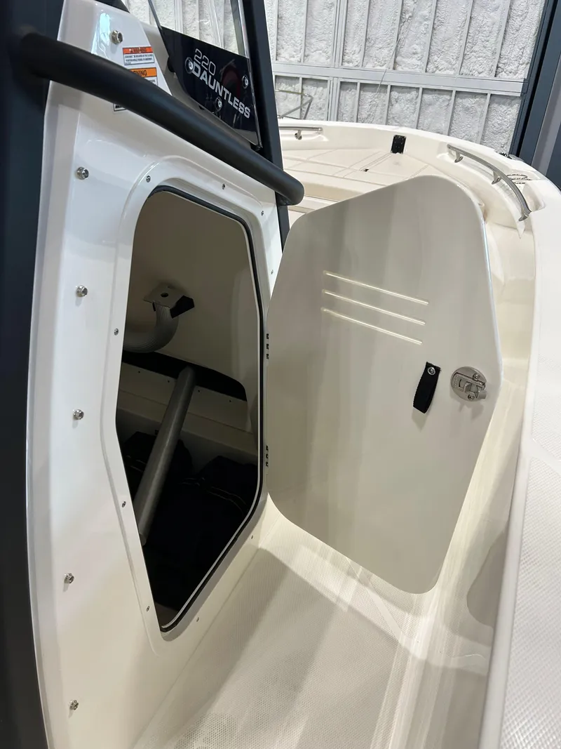 Slide: The Image of 2025 Boston Whaler 220 Dauntless boat with open storage compartment door. - 9