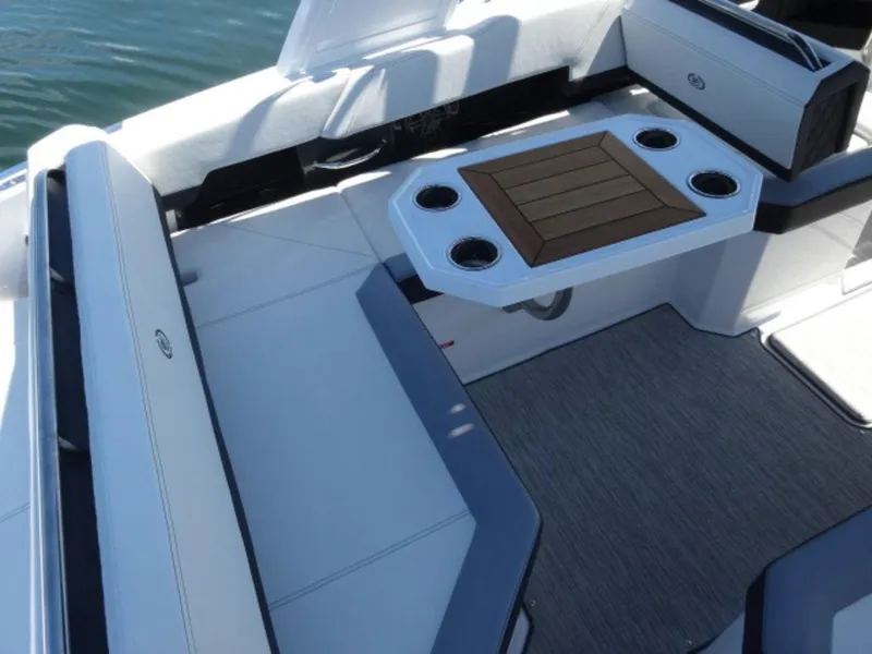Slide: The Image of 2024 Cobalt R6 boat interior with seating and a table featuring cup holders. - 10