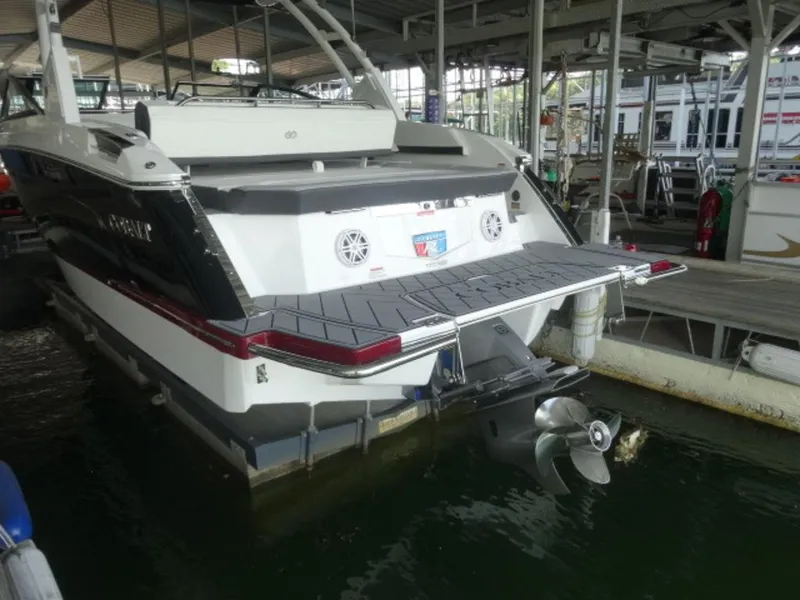 Slide: The Image of 2024 Cobalt R6 boat docked, showcasing rear deck and propeller in marina setting. - 4
