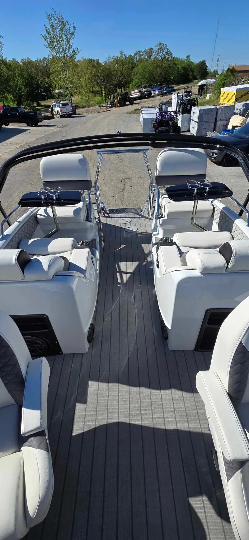 Slide: The Image of 2025 Manitou 25 LX SRW pontoon boat interior with white seating and sleek design. - 14