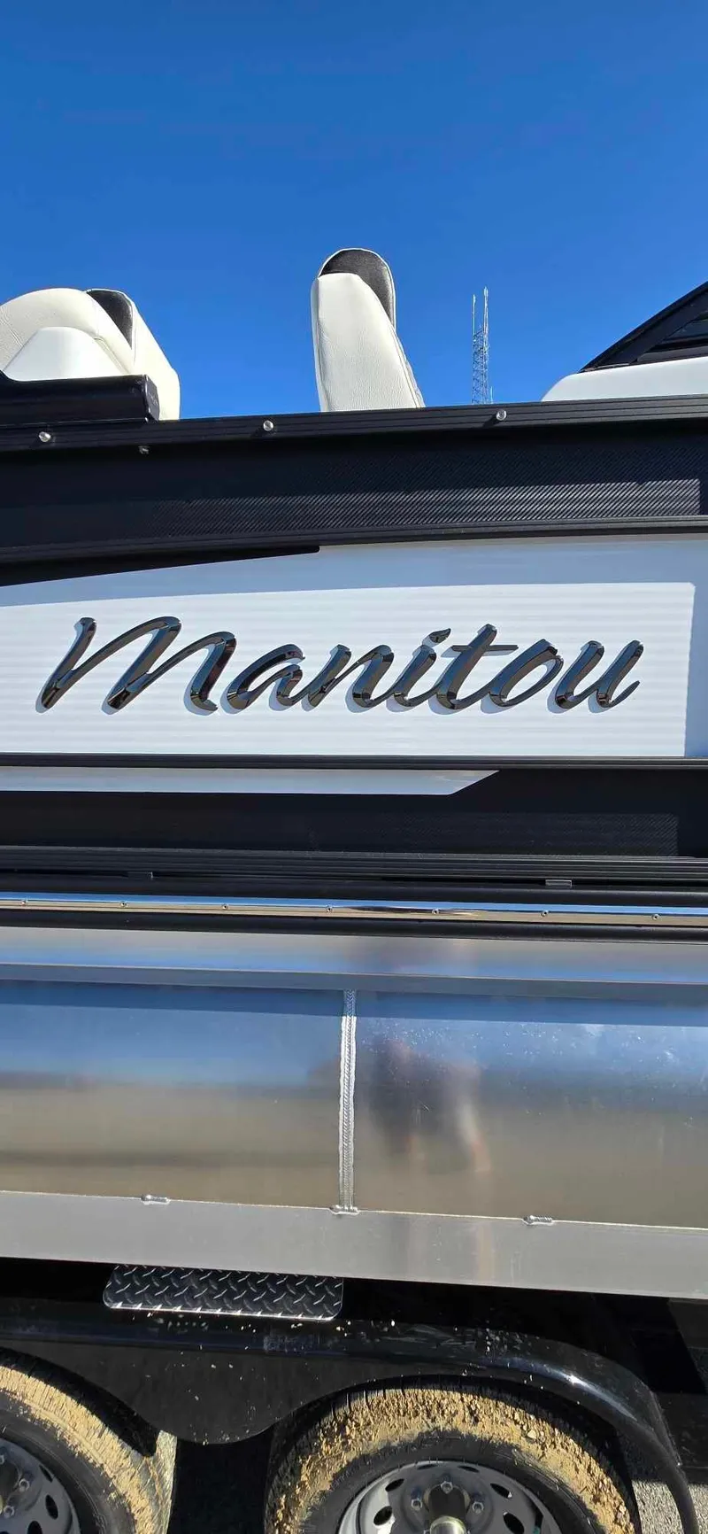 Slide: The Image of 2025 Manitou 25 LX SRW boat with sleek design against clear blue sky. - 19
