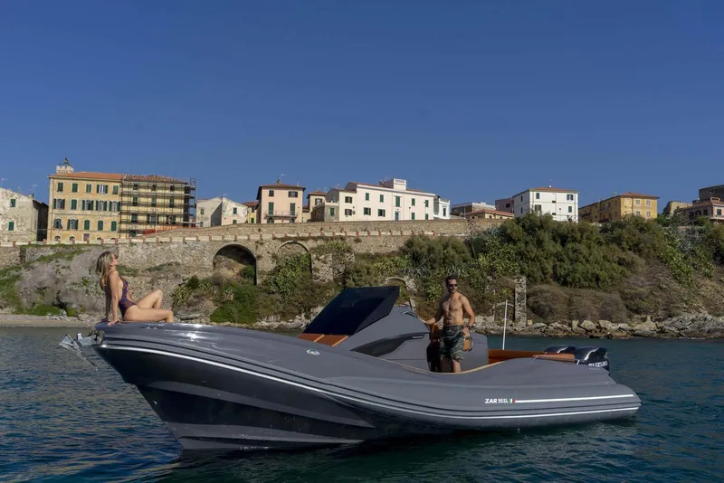 Slide: The Image of 2025 Zar Formenti 95 SL boat cruising near a coastal town. - 8