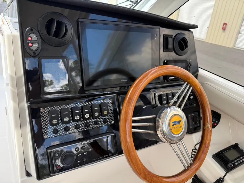 Slide: The Image of 2020 Cutwater C-24 DC boat interior with seating, helm, and blue LED lighting at a dock. - 20