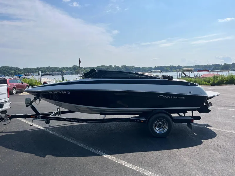 Slide: The Image of 2014 Crownline 18 SS boat on trailer, parked near a scenic lake. - 3