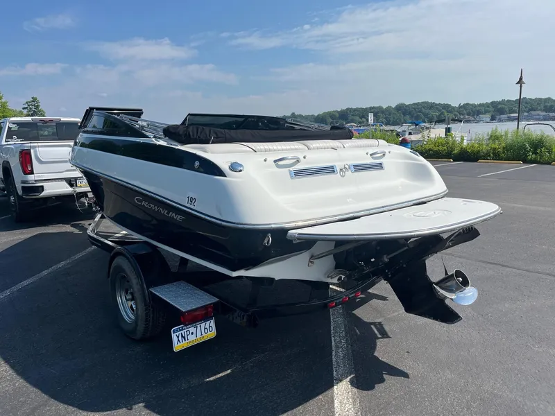 Slide: The Image of 2014 Crownline 18 SS boat on trailer in parking lot near lake. - 4