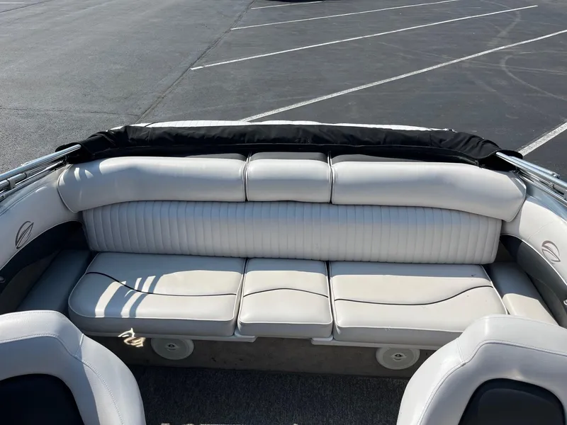 Slide: The Image of 2014 Crownline 18 SS boat interior with white seating in a parking lot. - 8