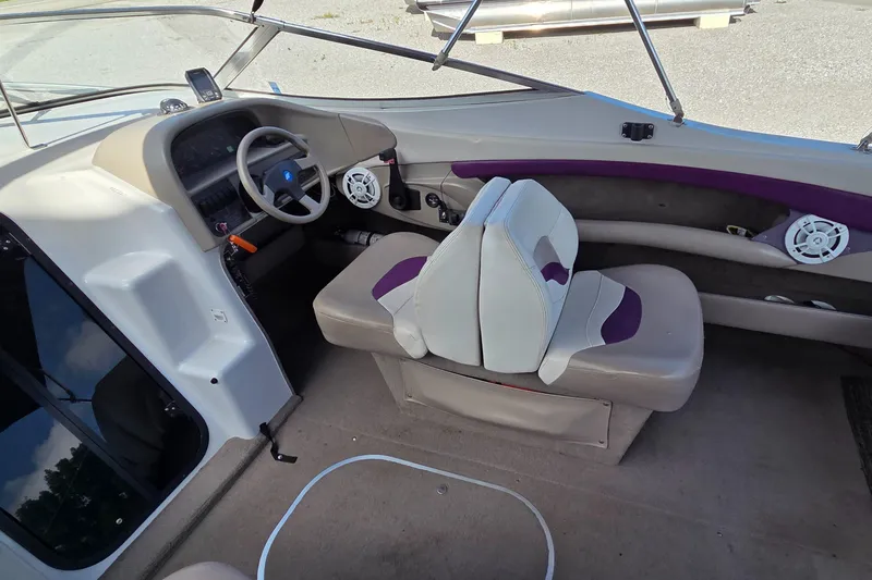 Slide: The Image of Interior of a 1995 Four Winns 245 Sundowner boat, featuring steering wheel and seating. - 6