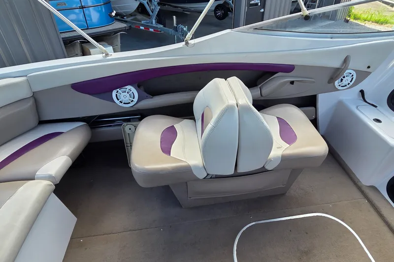 Slide: The Image of Interior of a 1995 Four Winns 245 Sundowner boat with purple-accented seating. - 7