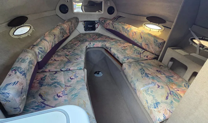 Slide: The Image of Interior of 1995 Four Winns 245 Sundowner boat with patterned seating and portholes. - 8