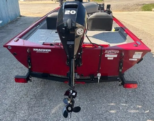 Slide: The Image of 2024 Tracker Pro 170 boat, red exterior, rear view with motor, parked on pavement. - 3