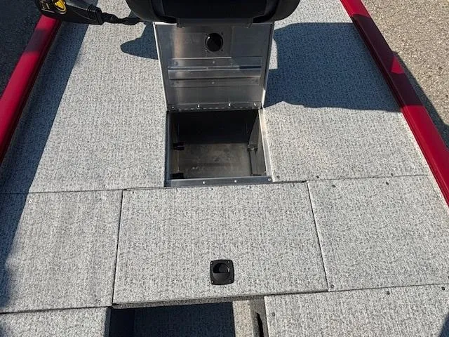 Slide: The Image of 2024 Tracker Pro 170 boat interior with open storage compartment, gray carpet, and red trim. - 9