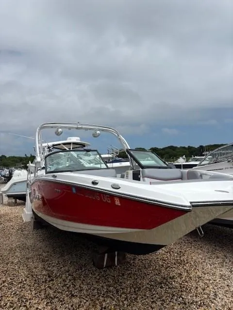 Slide: The Image of 2019 MasterCraft NXT22 boat with red and white exterior on a gravel surface. - 22