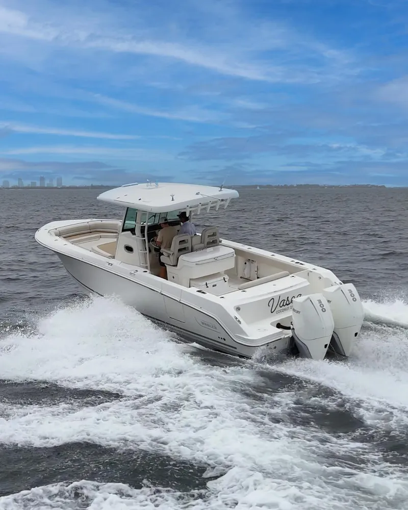 Slide: The Image of 2021 Boston Whaler 330 Outrage cruising on open water under a clear blue sky. - 10
