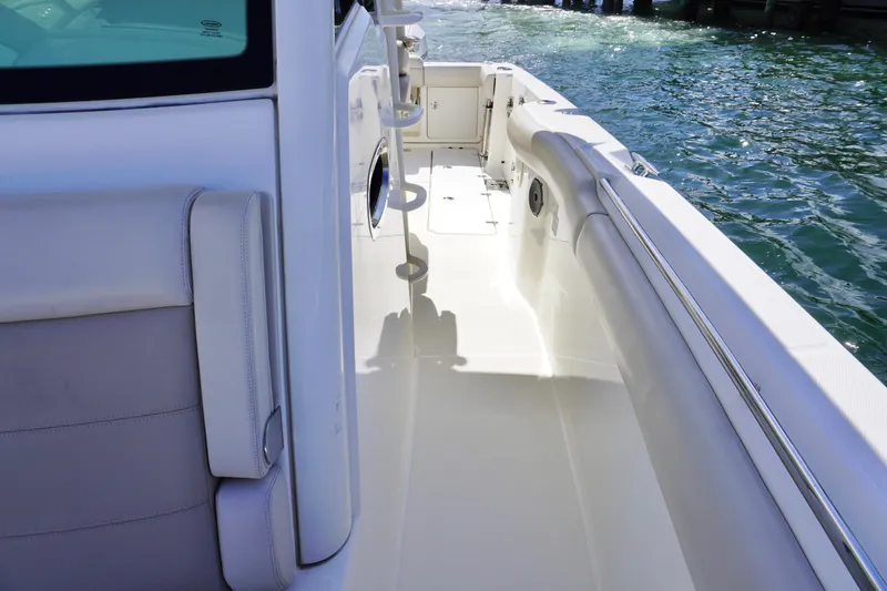 Slide: The Image of 2021 Boston Whaler 330 Outrage boat interior with white seating and ocean view. - 12