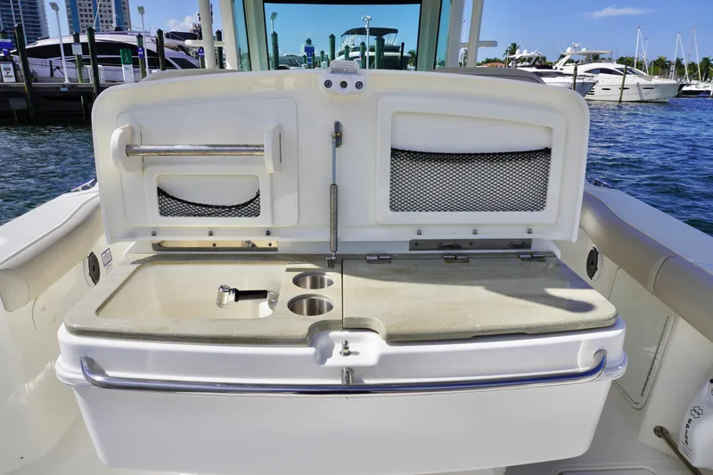 Slide: The Image of 2021 Boston Whaler 330 Outrage boat interior with storage compartments and cup holders. - 21