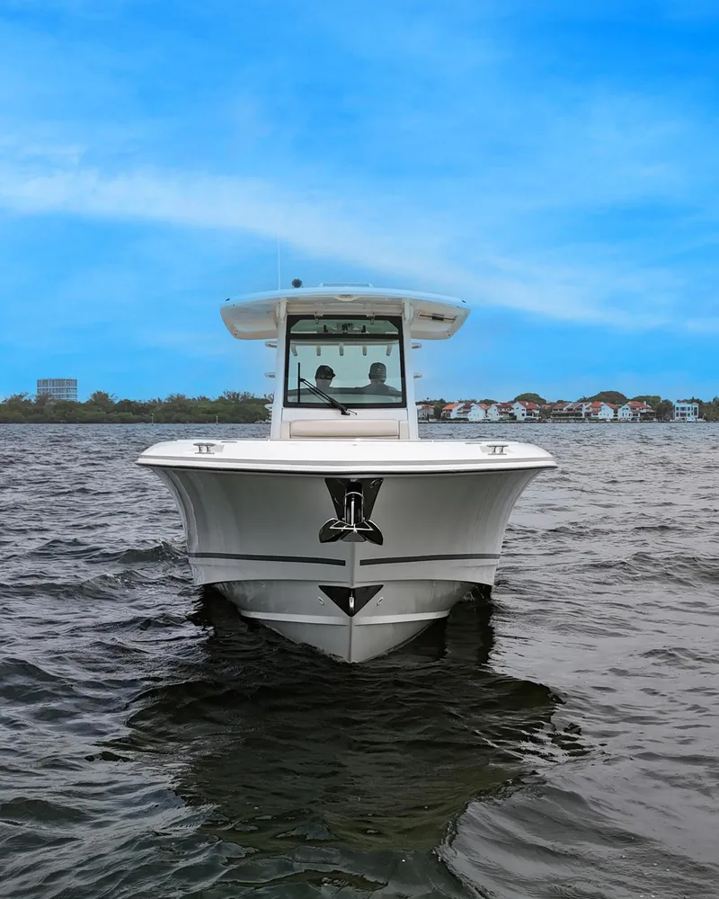 Slide: The Image of 2021 Boston Whaler 330 Outrage boat on water, clear blue sky background. - 3