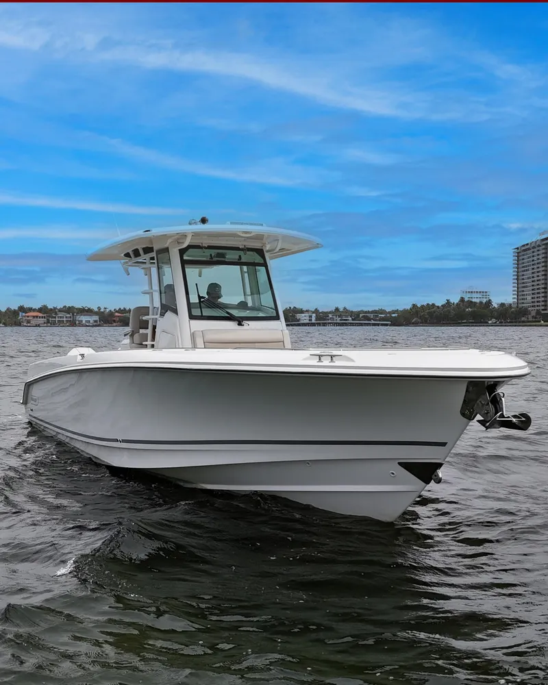 Slide: The Image of 2021 Boston Whaler 330 Outrage boat cruising on water under a clear blue sky. - 4