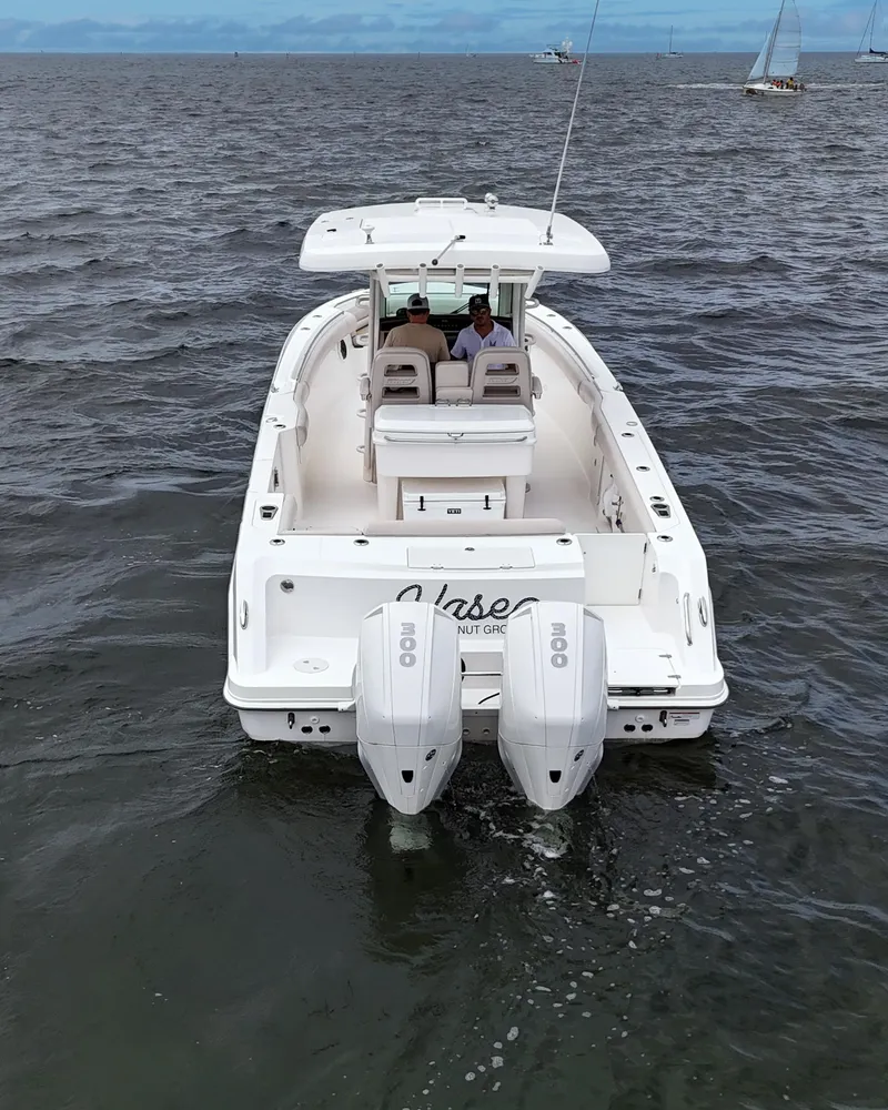 Slide: The Image of 2021 Boston Whaler 330 Outrage boat on open water, rear view with dual engines. - 5