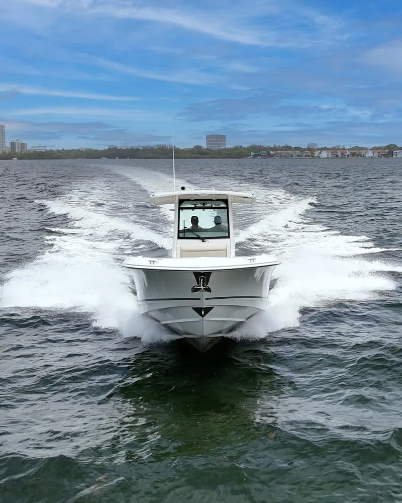 Slide: The Image of 2021 Boston Whaler 330 Outrage cruising on open water under a clear blue sky. - 8