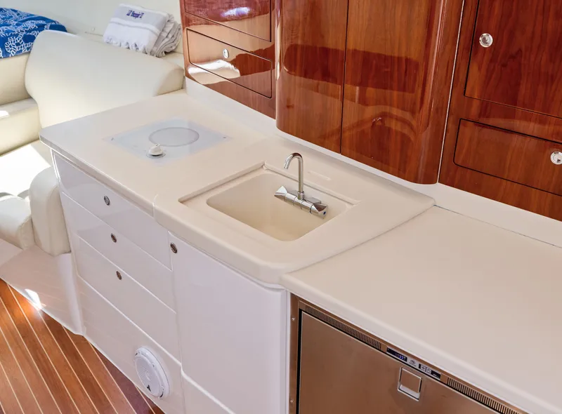 Slide: The Image of Luxurious 2015 Intrepid 430 Sport Yacht interior with sleek kitchenette and wooden cabinetry. - 18