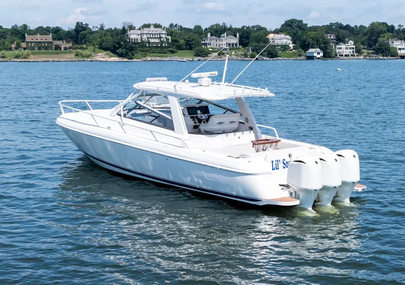 Slide: The Image of 2015 Intrepid 430 Sport Yacht on serene water with scenic shoreline background. - 2