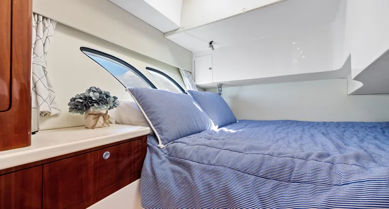 Slide: The Image of Luxurious cabin interior of 2015 Intrepid 430 Sport Yacht with blue bedding and elegant decor. - 23
