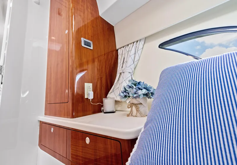 Slide: The Image of Interior of 2015 Intrepid 430 Sport Yacht with wood paneling and striped cushion. - 24