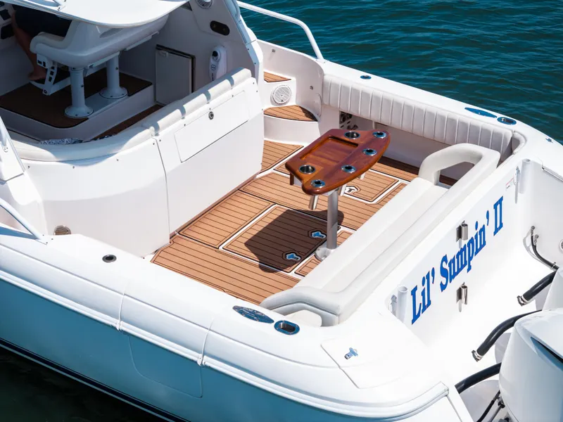 Slide: The Image of 2015 Intrepid 430 Sport Yacht deck with seating and table, on water. - 5