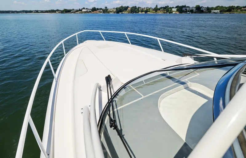 Slide: The Image of 2015 Intrepid 430 Sport Yacht on calm water, showcasing sleek design and spacious deck. - 6