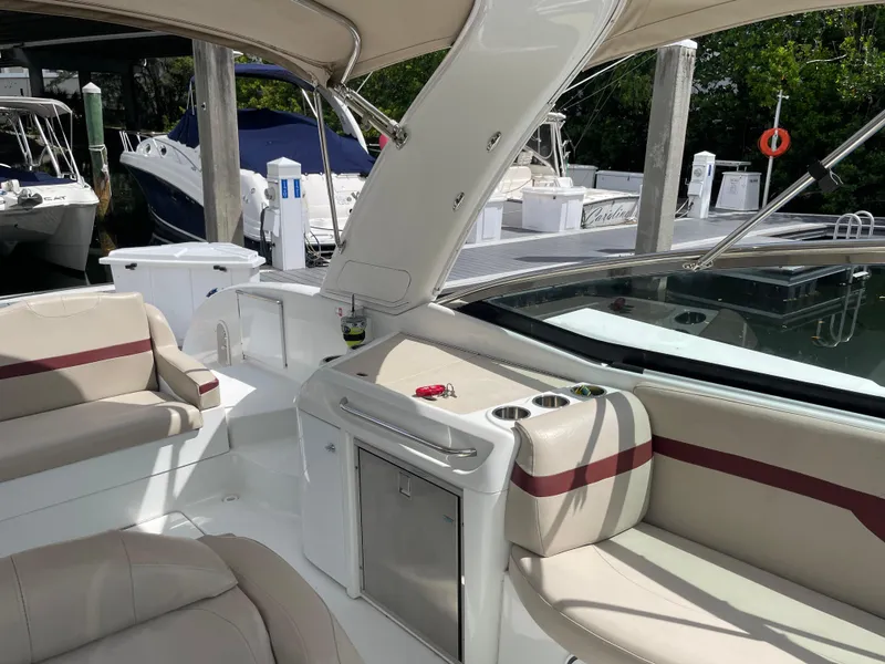 Slide: The Image of 2010 Formula 350ss boat interior with beige seating and docked boats in background. - 14