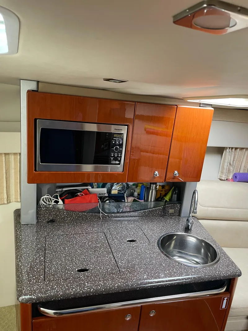 Slide: The Image of Compact kitchen area in a 2010 Formula 350ss boat with microwave and sink. - 30