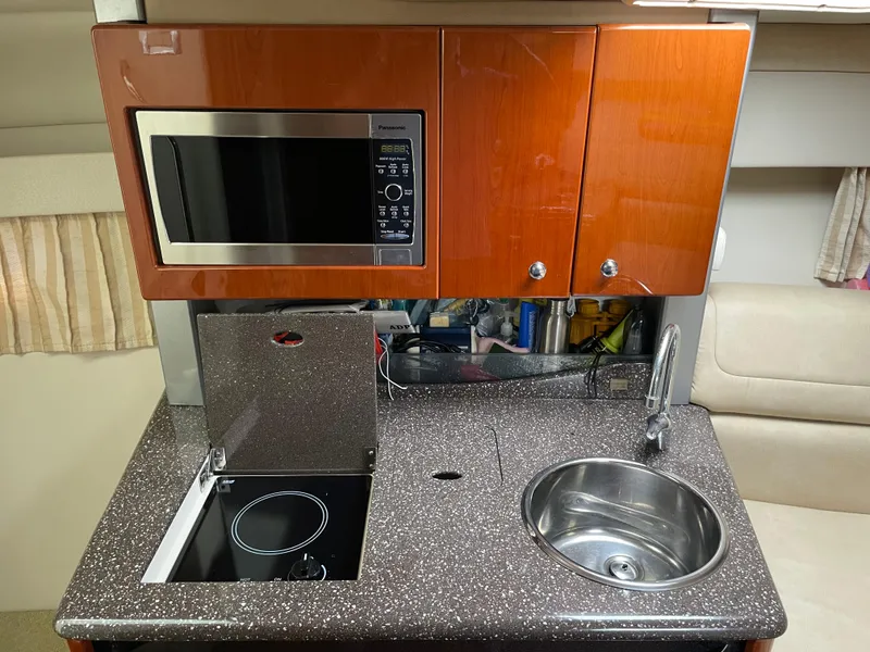 Slide: The Image of Compact kitchen in a 2010 Formula 350ss boat with microwave, stove, and sink. - 31