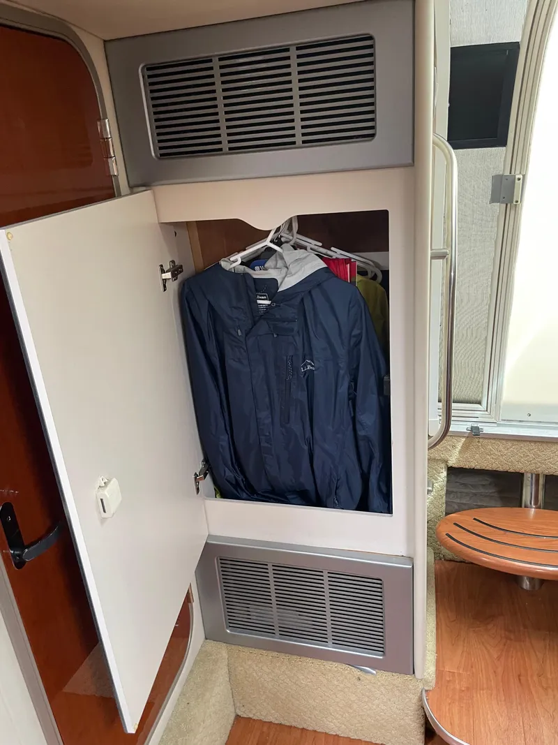 Slide: The Image of Closet in 2010 Formula 350ss boat with hanging jackets and wooden interior. - 37