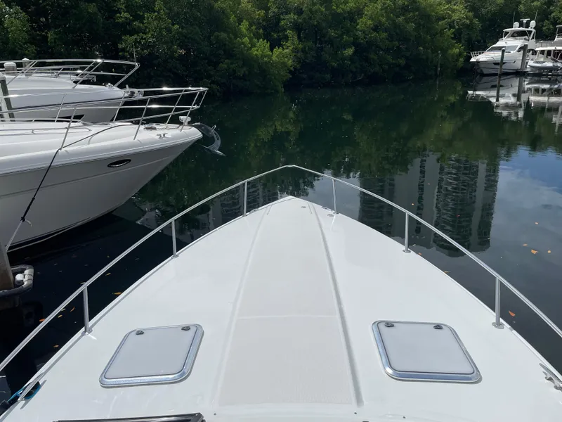 Slide: The Image of Bow view of a 2010 Formula 350ss boat docked near lush greenery. - 46