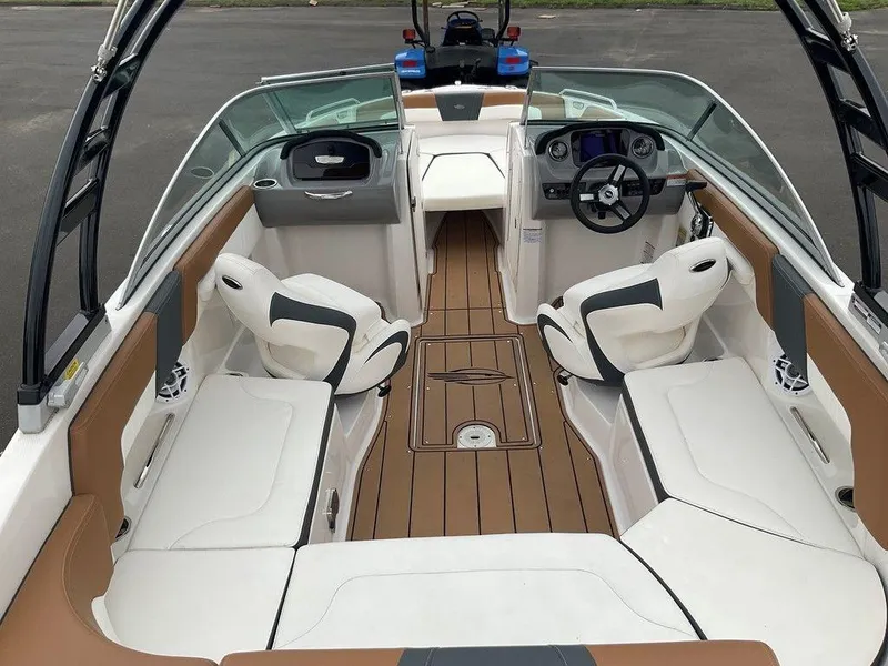 Slide: The Image of 2023 Chaparral 23 SSi boat interior with white seating and modern dashboard. - 12