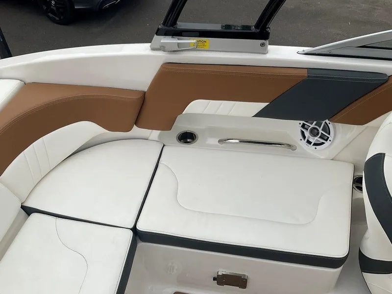 Slide: The Image of 2023 Chaparral 23 SSi boat interior with white and brown seating, speaker, and handle. - 16
