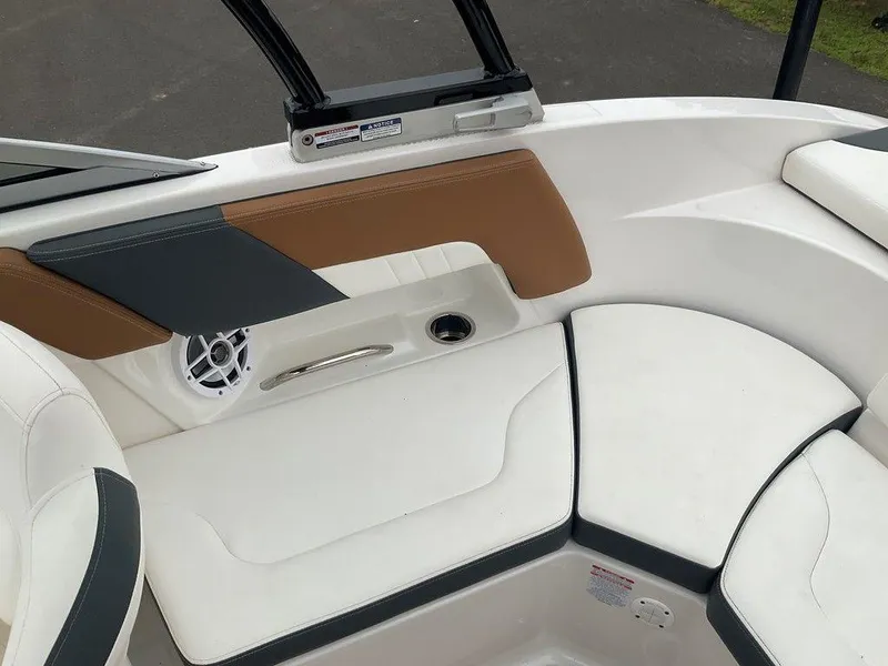 Slide: The Image of Interior seating of 2023 Chaparral 23 SSi boat, featuring white and tan upholstery. - 19
