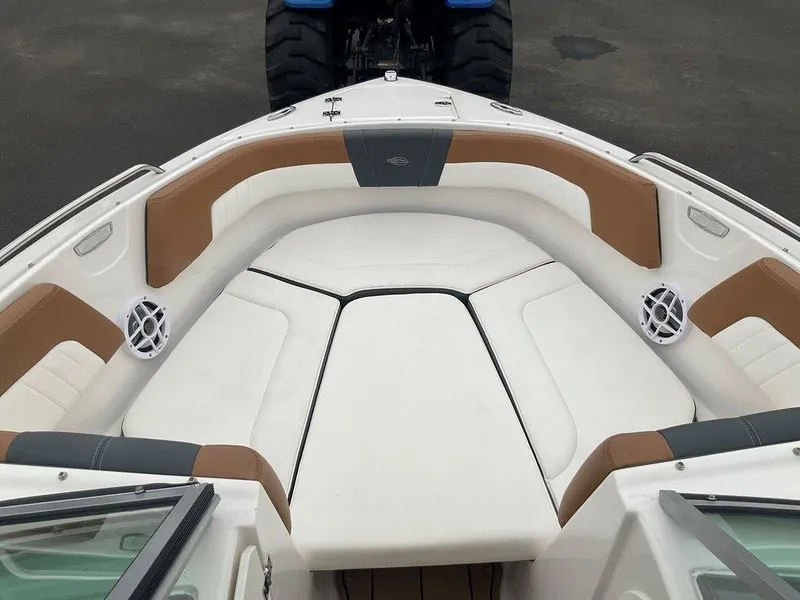 Slide: The Image of 2023 Chaparral 23 SSi boat interior with white and brown seating, speakers, and windshield. - 21