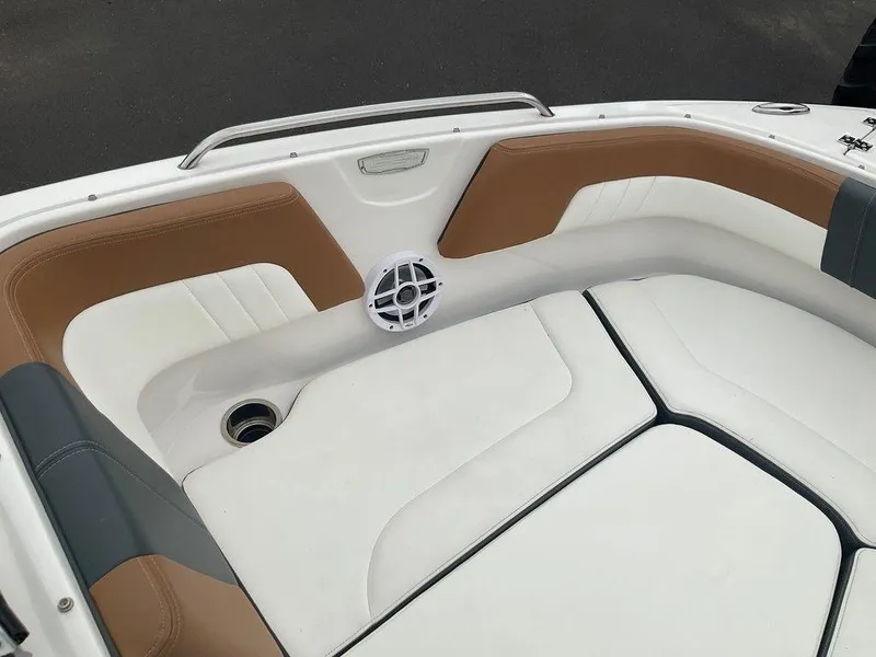 Slide: The Image of 2023 Chaparral 23 SSi boat interior with tan and white seating, speaker, and cup holder. - 22