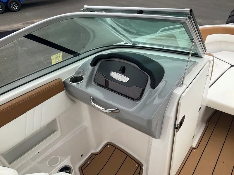 Slide: The Image of 2023 Chaparral 23 SSi boat interior with sleek dashboard and cup holder. - 23