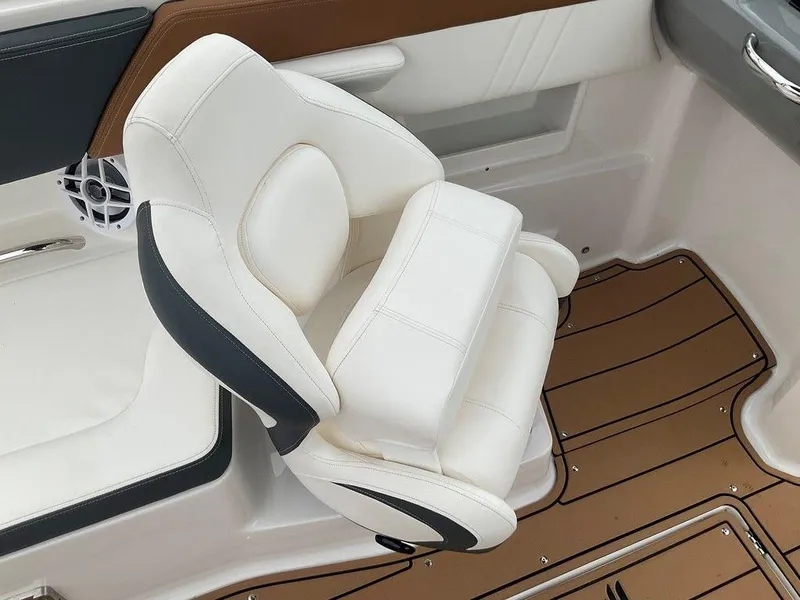 Slide: The Image of 2023 Chaparral 23 SSi boat interior with white cushioned seat and brown flooring. - 24