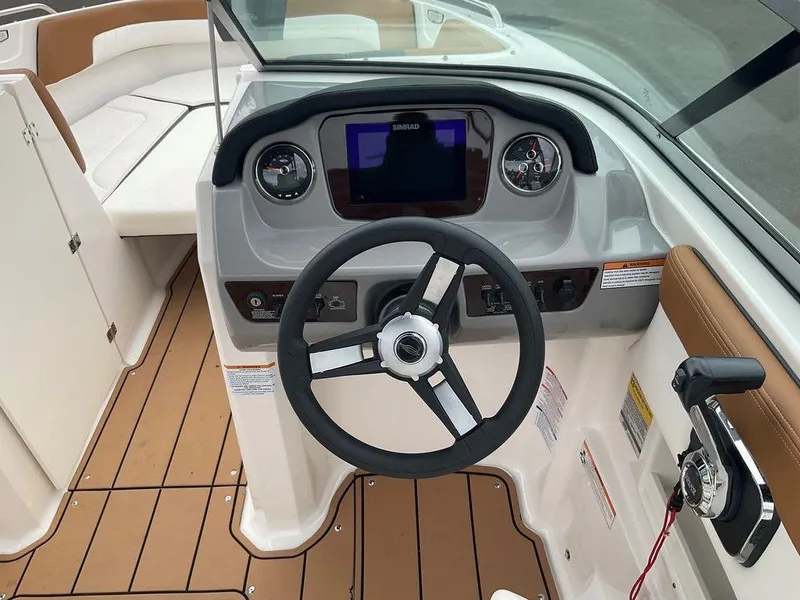 Slide: The Image of 2023 Chaparral 23 SSi boat cockpit with steering wheel and dashboard controls. - 25