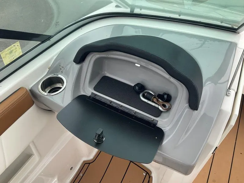 Slide: The Image of 2023 Chaparral 23 SSi boat dashboard with cup holder and storage compartment. - 27