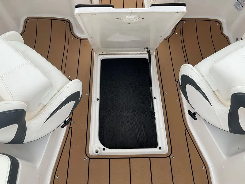 Slide: The Image of 2023 Chaparral 23 SSi boat interior with open storage compartment and white seating. - 28