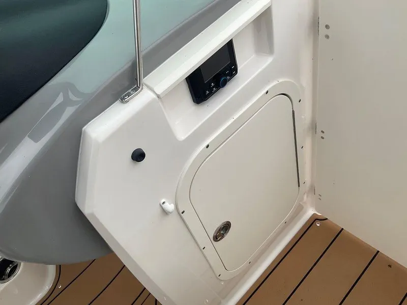 Slide: The Image of 2023 Chaparral 23 SSi boat interior with control panel and storage compartment. - 29