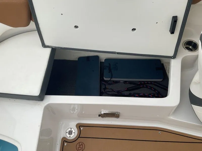 Slide: The Image of 2023 Chaparral 23 SSi boat storage compartment with open hatch and visible ropes. - 31